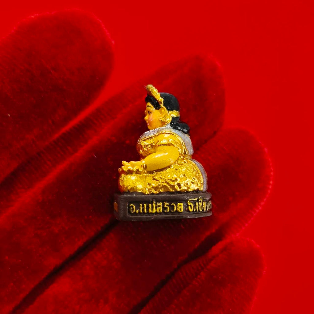 Nang Kwak amulet for wealth small gold painted Thai beckoning goddess figurine displayed on red velvet glove