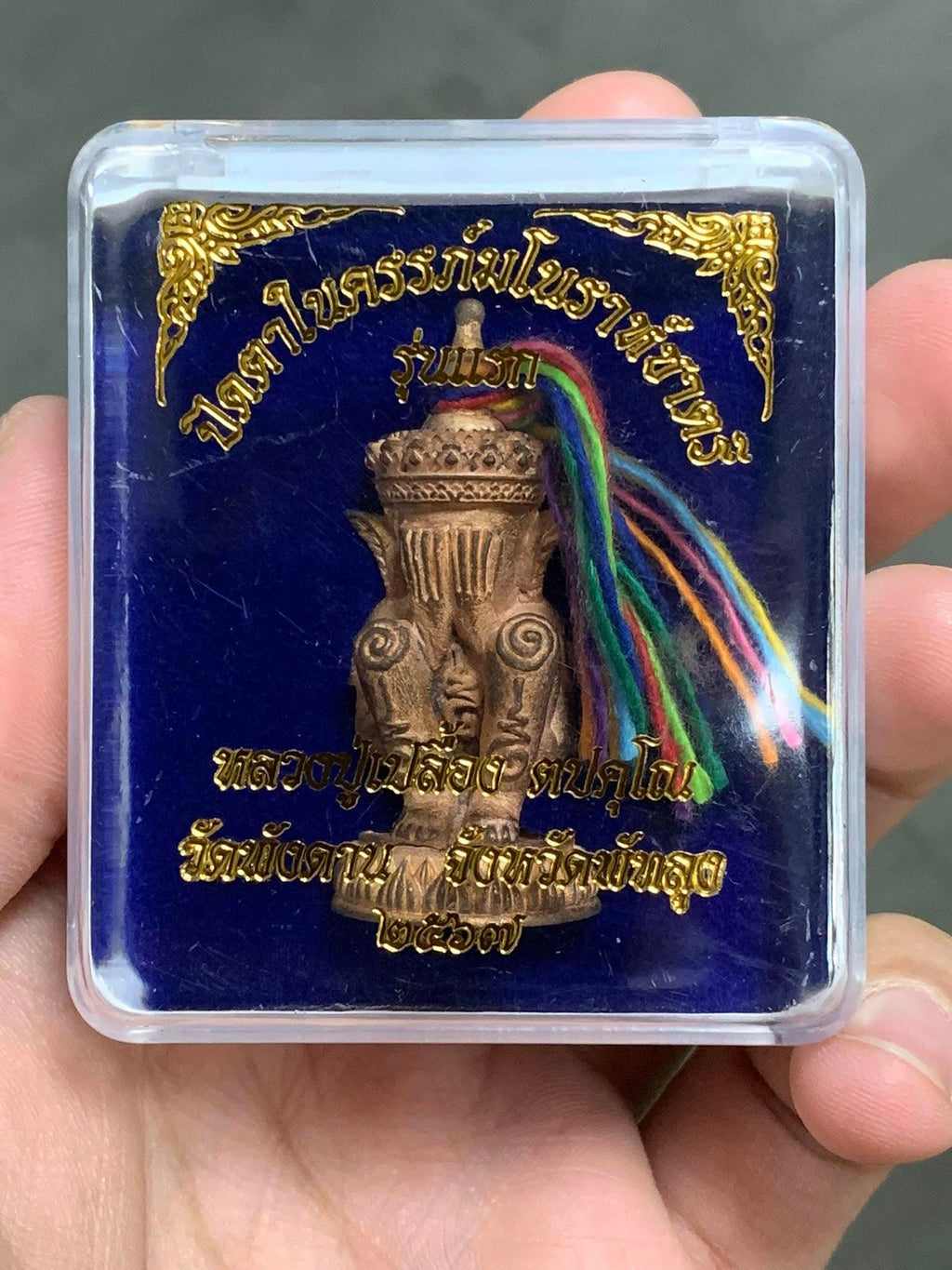 Norah Chatri Pi Takta amulet for protection in clear display case with bronze figurine and multicolor cords