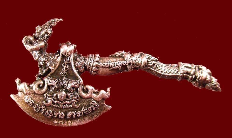 Ornate metal ceremonial axe amulet with intricate Thai motifs and mythical creature handle Phaya Khwan Maha Prap Amulet .