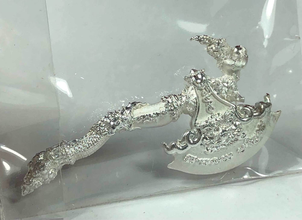 Silver ornate ceremonial axe amulet with Thai floral engravings on white background Phaya Khwan Maha Prap Amulet Tak Sila Edition