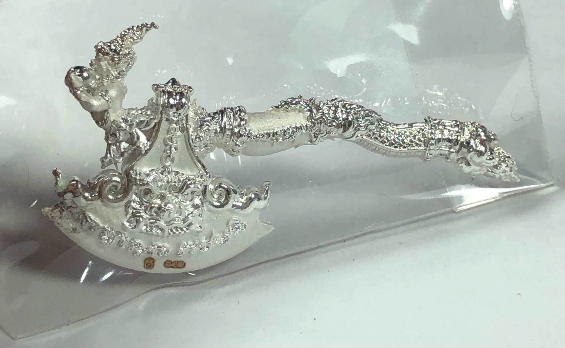 Phaya Khwan Maha Prap Amulet Tak Sila Edition ornate silver ceremonial amulet with decorative handle on clear plastic