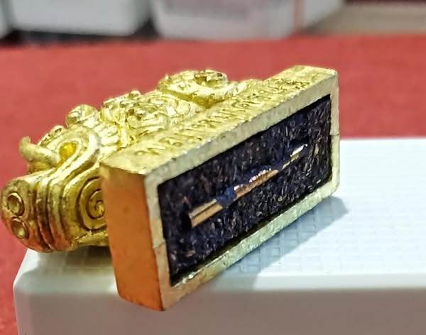Gold Phaya Moo Setthi - Luang Por Whan amulet with rectangular black base and embedded metal pin for talisman use