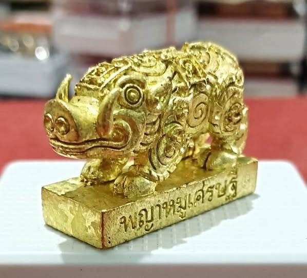 Phaya Moo Setthi - Luang Por Whan gold pig amulet with ornate swirls and Thai inscription on base