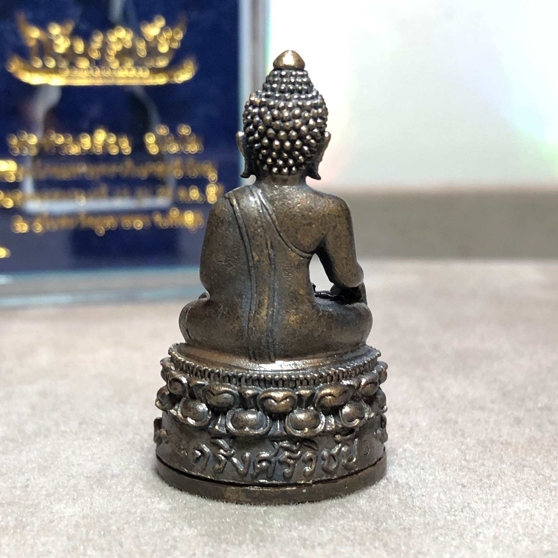 Phra Kring Srivichai amulet metal seated Buddha statue back view on ornate lotus base with Thai script by Thai Blessing Co