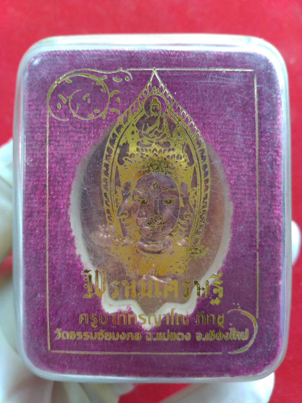 Phra Phrom Thai amulet for wealth in clear plastic display box with purple velvet backing and gold print