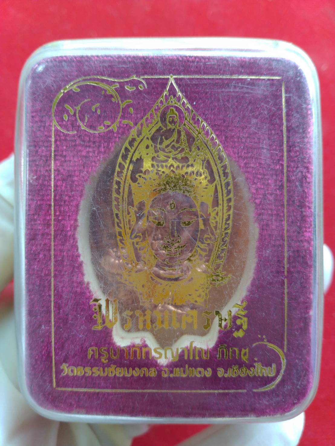 Phra Phrom Thai amulet for wealth in clear plastic display box with purple velvet backing and gold print