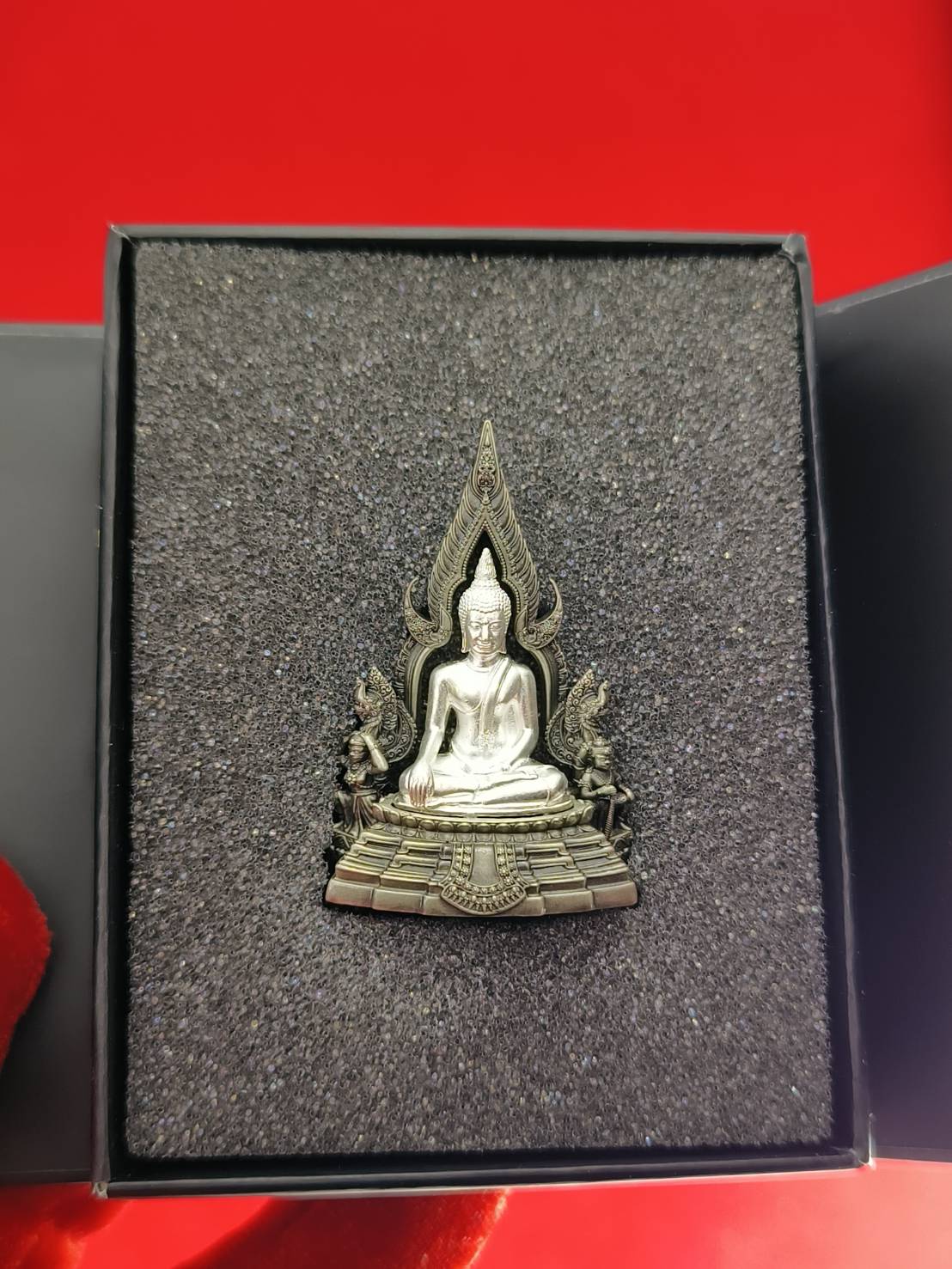 Phra Phuttha Chinnarat amulet silver seated Buddha in ornate frame on foam inside black gift box by Thai Blessing Co