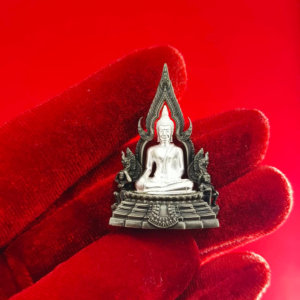 Phra Phuttha Chinnarat amulet silver Buddha pendant held on red velvet gloved hand for home shrine