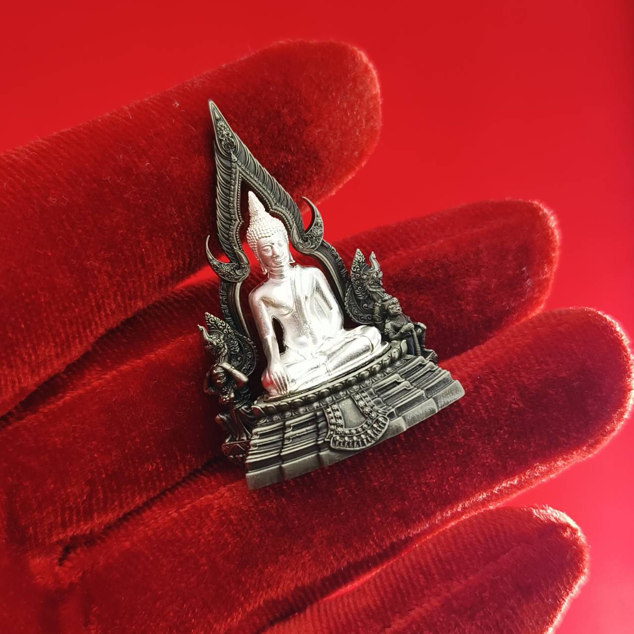 Thai Blessing Co Phra Phuttha Chinnarat amulet silver seated Buddha on ornate base held on red velvet glove