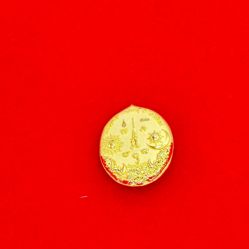 Gold round Rahu deity amulet medallion with intricate Thai engravings on red background by Thai Blessing Co