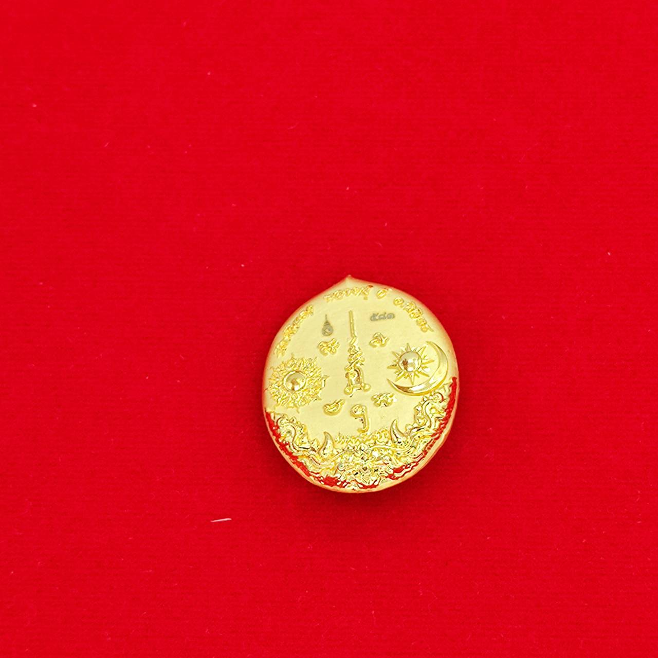 Gold circular Rahu deity amulet with intricate engravings on red background Thai Blessing Co collectible