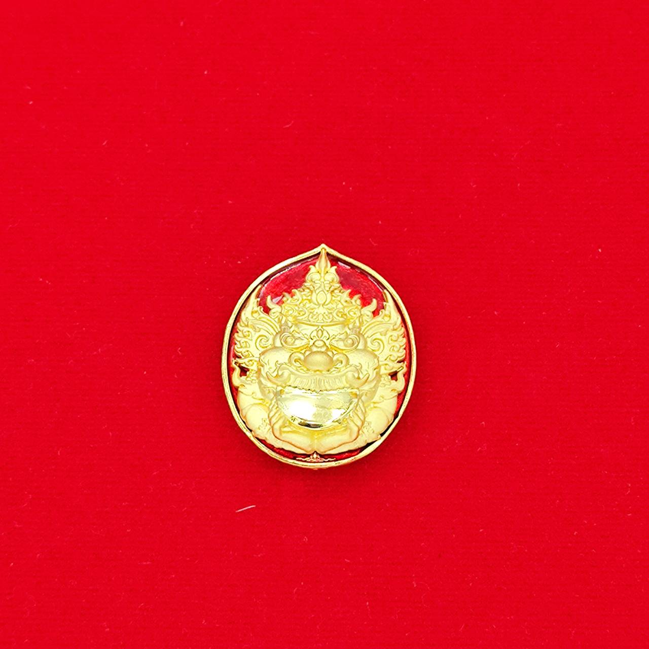 Thai Blessing Co gold Rahu deity amulet medallion with intricate mask design on red background