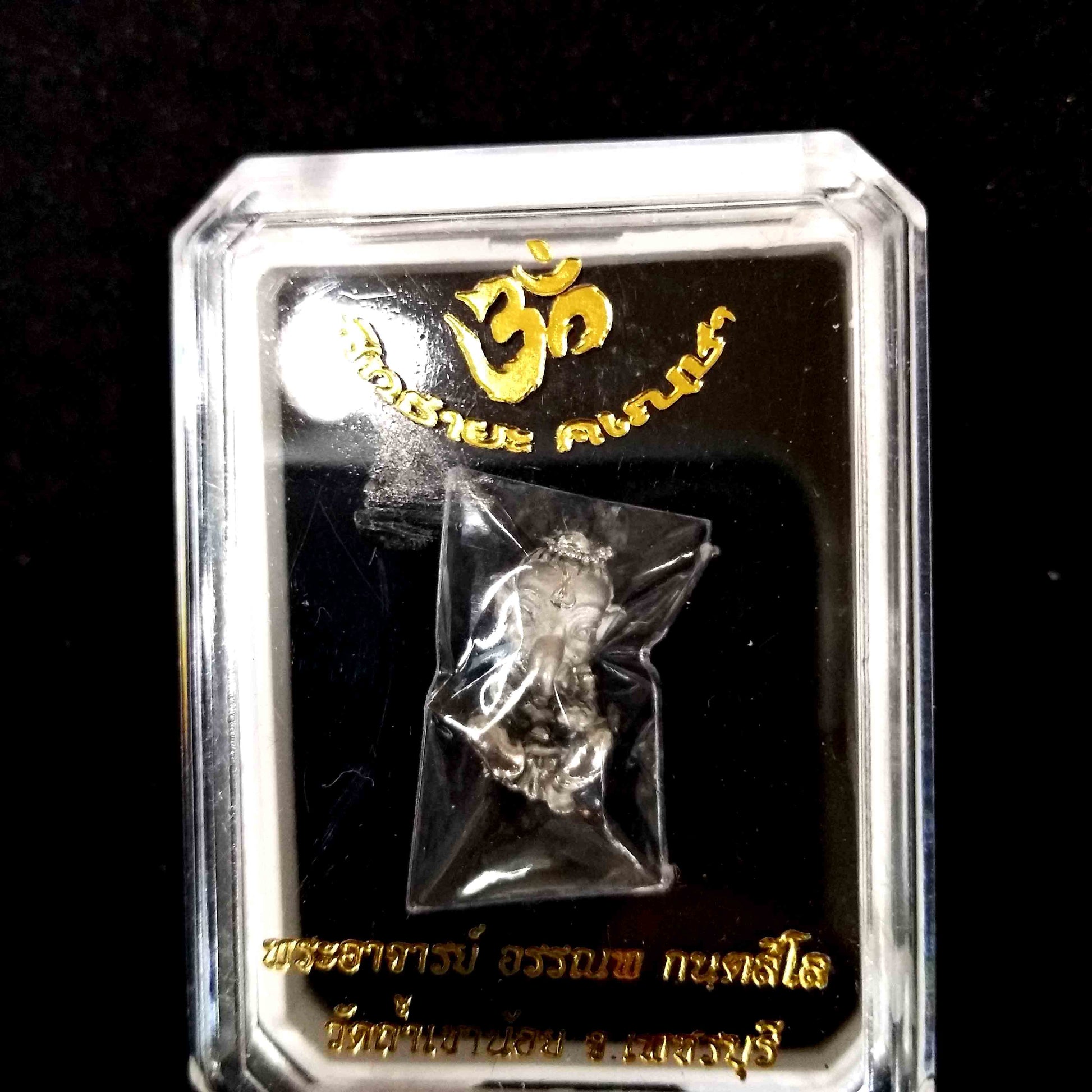 Sacred Thai Ganesh pendant in clear plastic display case with gold Thai script and Om symbol