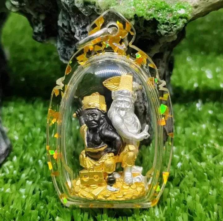 Tua Pae-Yee Pae Amulet - 2 Deities of Wealth. Small clear amulet with two gold and silver deity figures on pile of coins