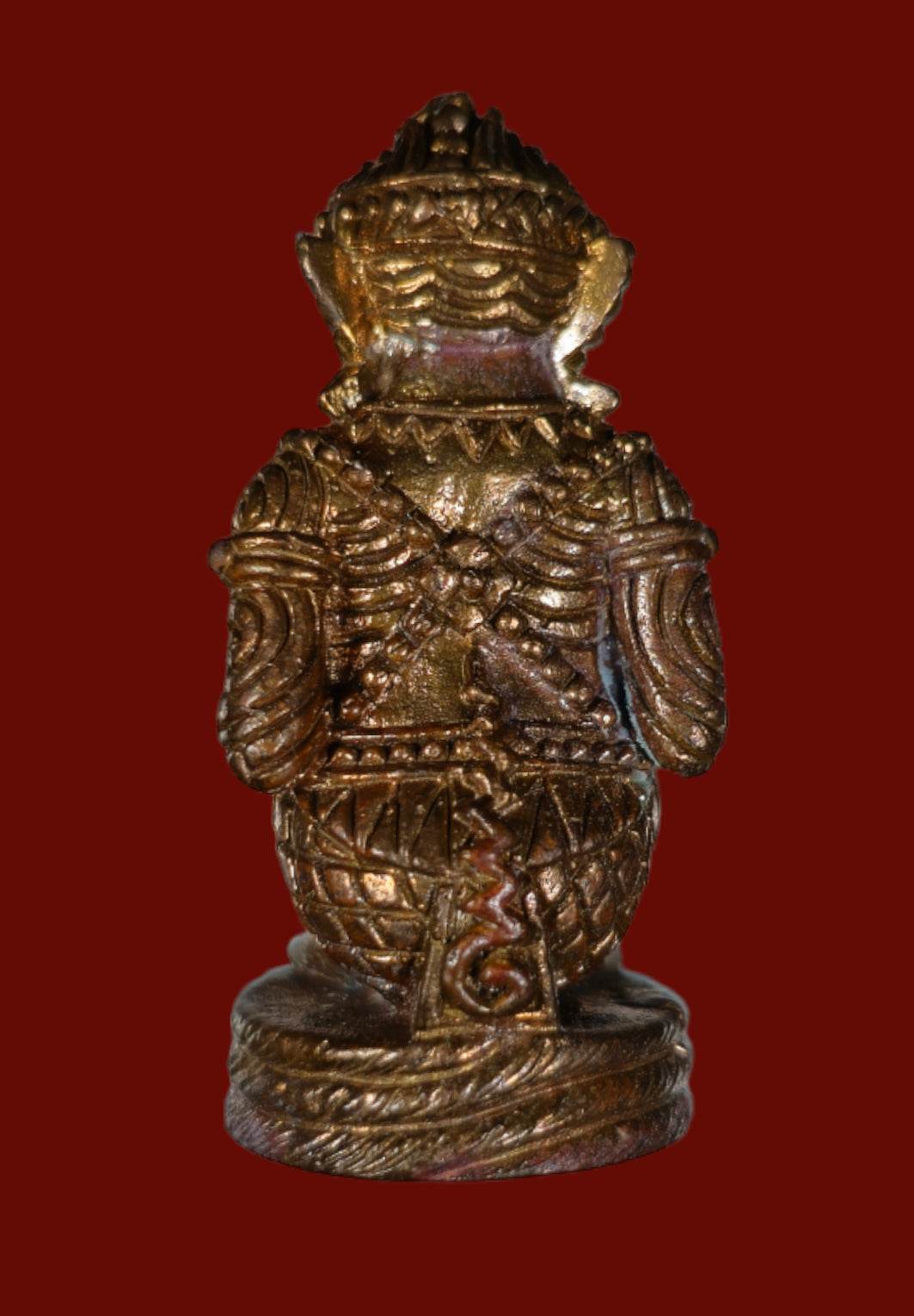Small bronze statuette ornament showing rear of authentic Thai Hanuman amulet with carved details and aged patina