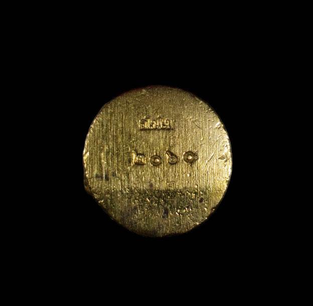 authentic Thai Hanuman amulet gold round medallion with stamped Thai script and serial number on black background