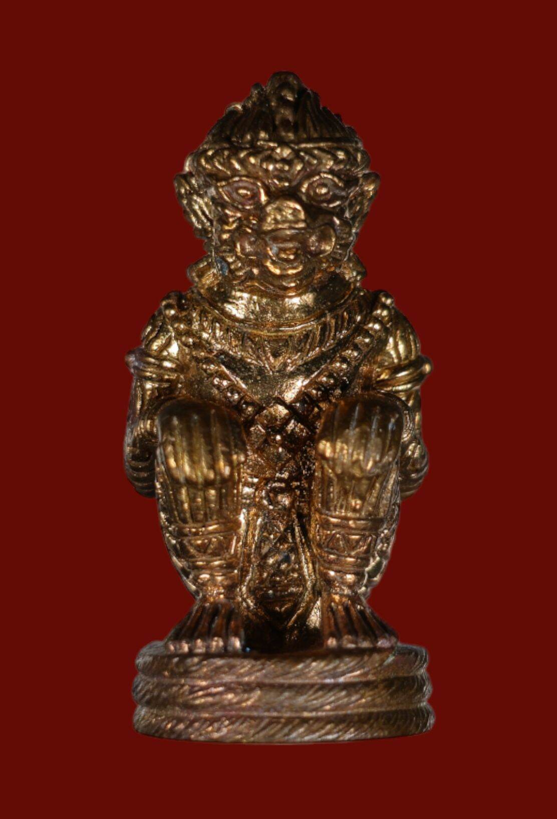 Small gold authentic Thai Hanuman amulet figurine standing on round base with intricate carved details