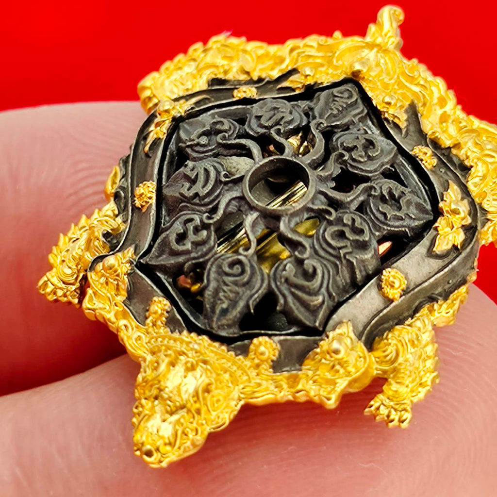 Kassapo Turtle wealth amulet ornate gold plated turtle talisman with black carved center held on fingers
