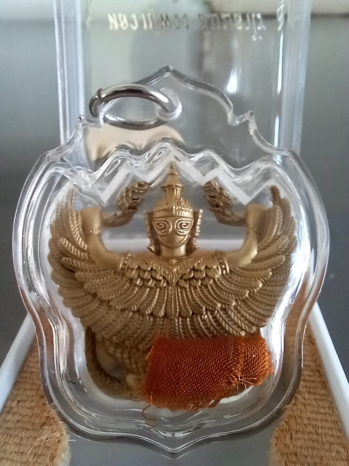 Thai Blessing Co Phaya Krut Garuda Amulet gold pendant in clear plastic case with orange cloth relic