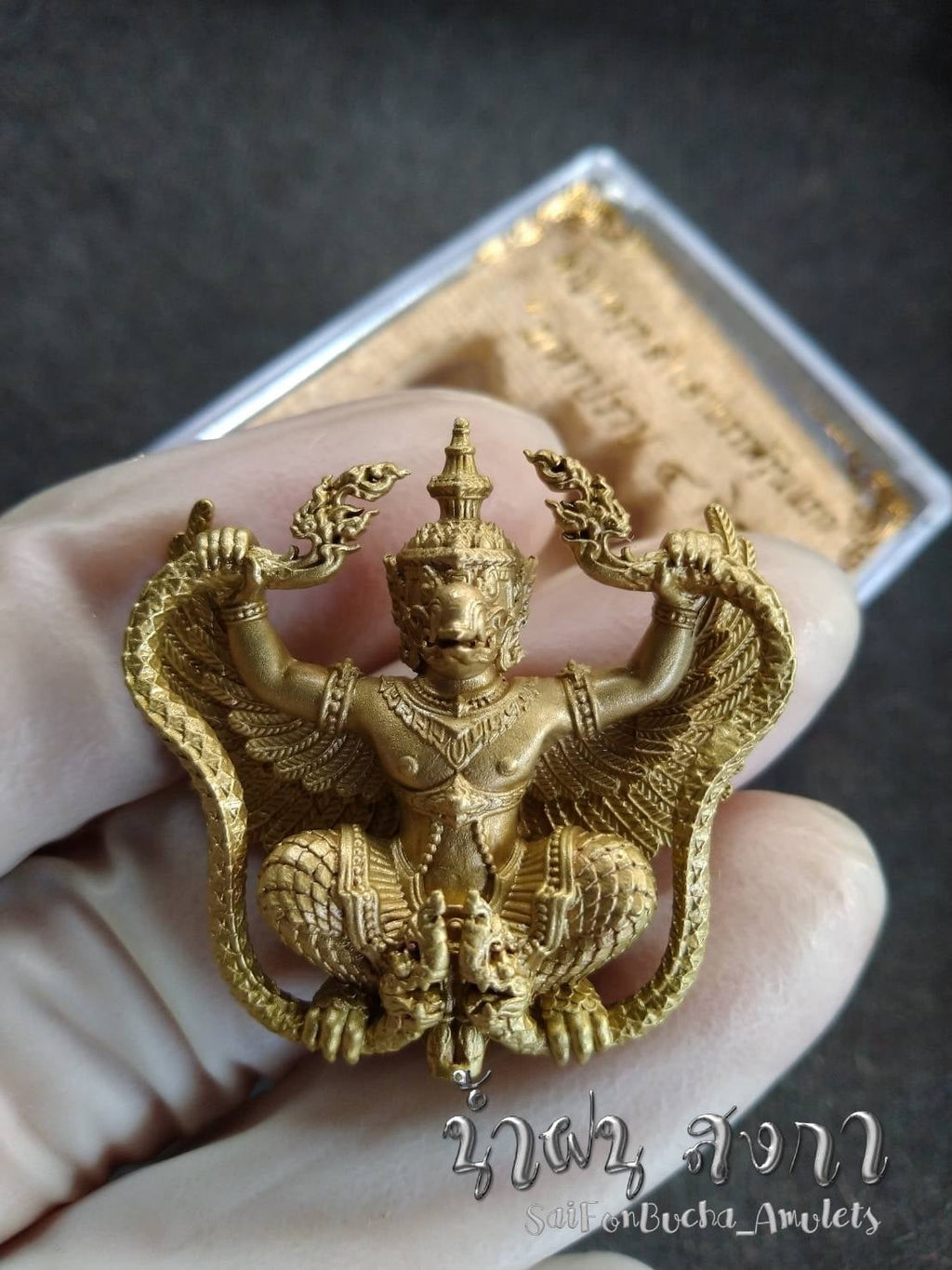 Gold Phaya Krut Garuda Amulet pendant with detailed wings and ornate Thai deity design held in hand