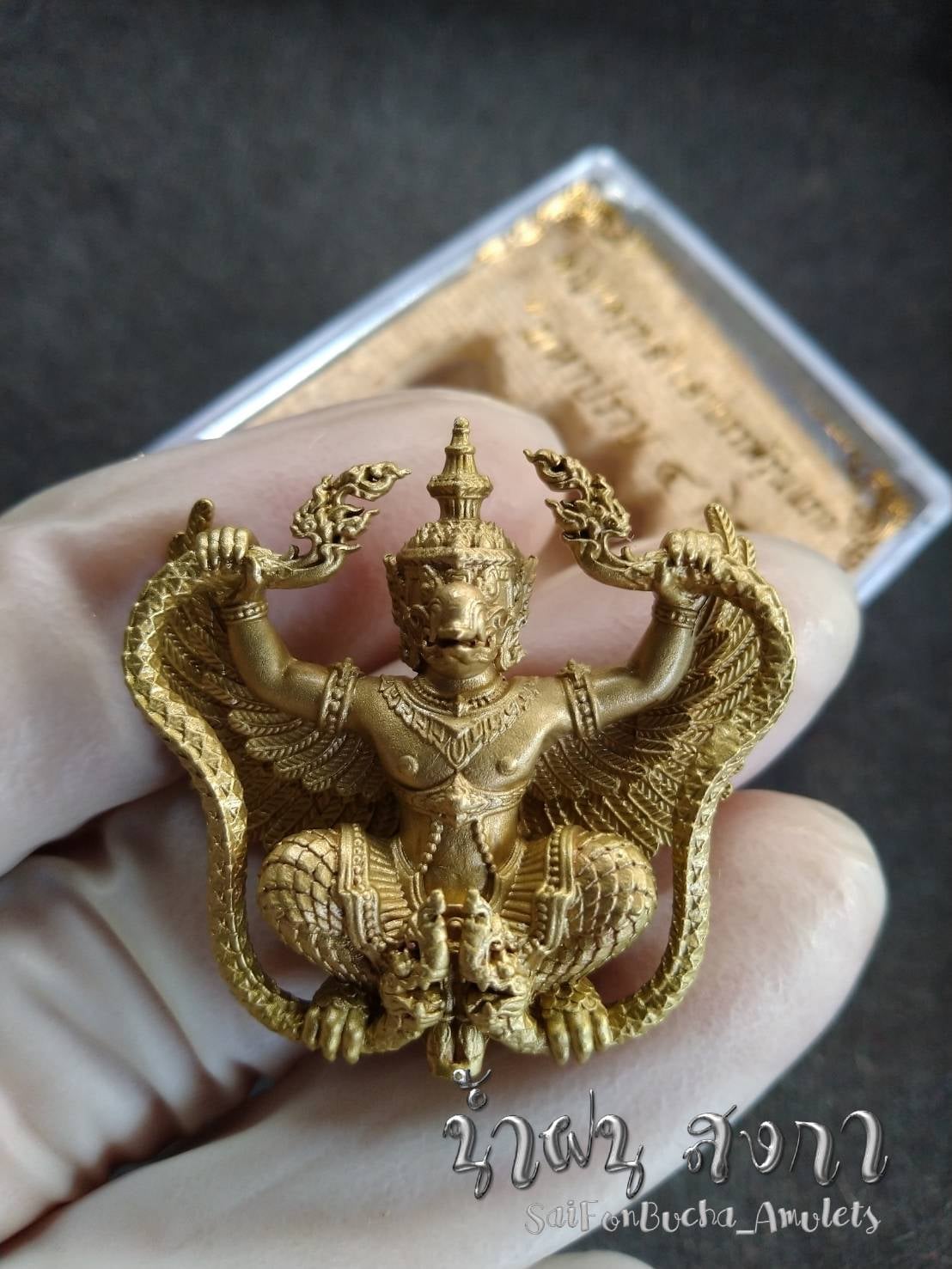 Gold Phaya Krut Garuda Amulet pendant with detailed wings and ornate Thai deity design held in hand