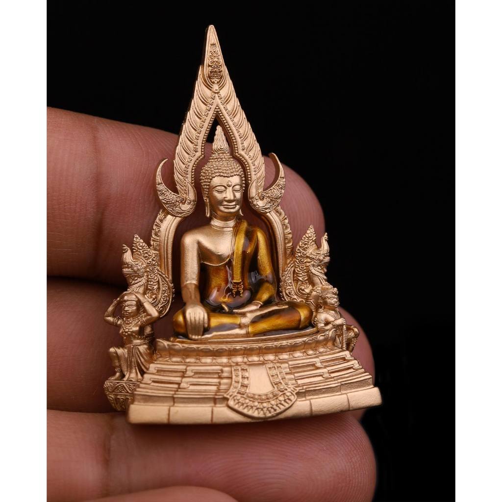 Phra Put Chinnarat amulet gold miniature seated Buddha with ornate Thai shrine frame held between fingers