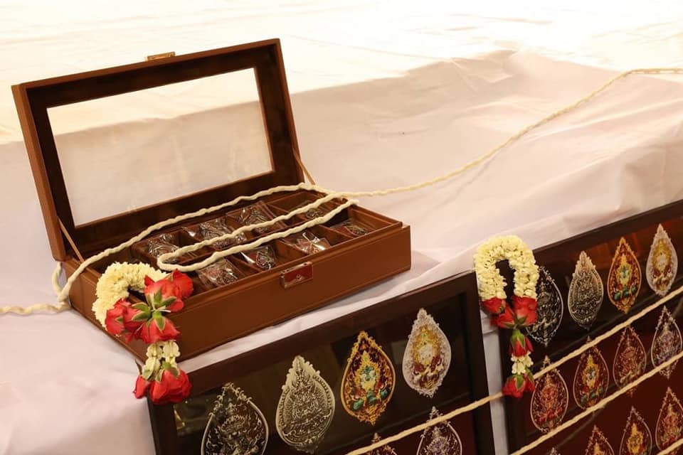 Thao Wessuwan amulet for protection displayed in a decorative wooden box with floral accents