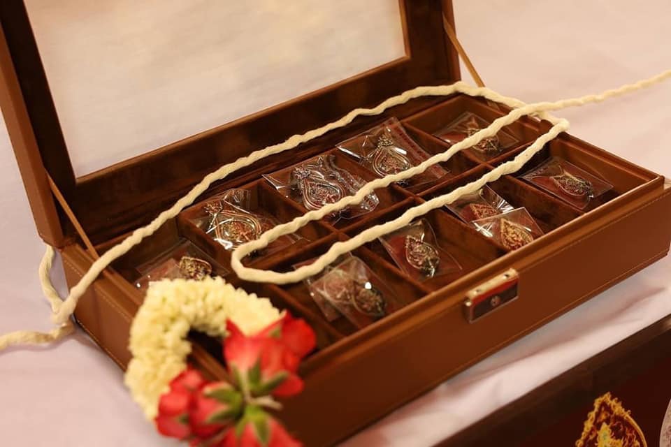 Thao Wessuwan amulet for protection displayed in a wooden box with floral decor