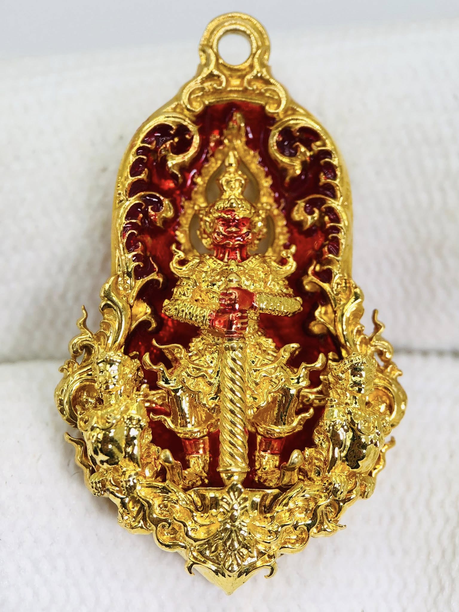 Thao Wessuwan amulet for sale featuring intricate gold detailing and vibrant red accents