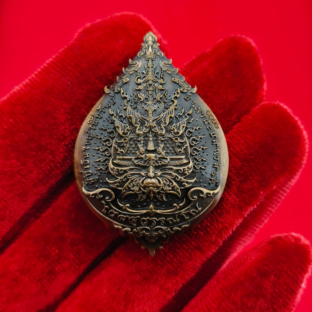 Thao Wessuwan amulet for wealth with intricate design on a decorative red background