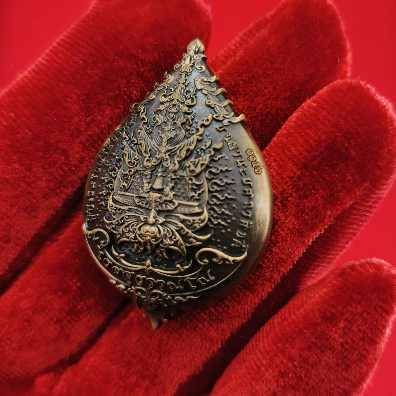 Thao Wessuwan amulet for wealth displayed on a red velvet background showcasing intricate details