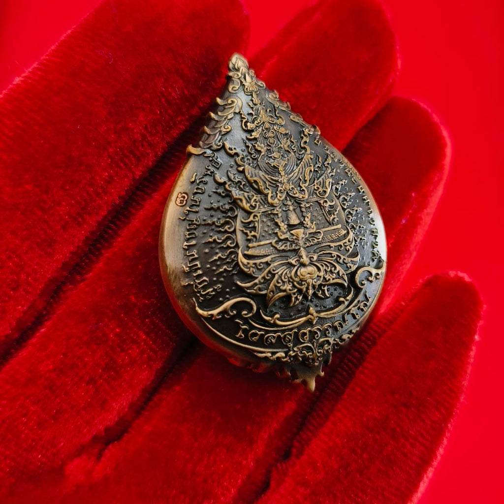 Thao Wessuwan amulet for wealth with intricate design displayed on a red velvet background