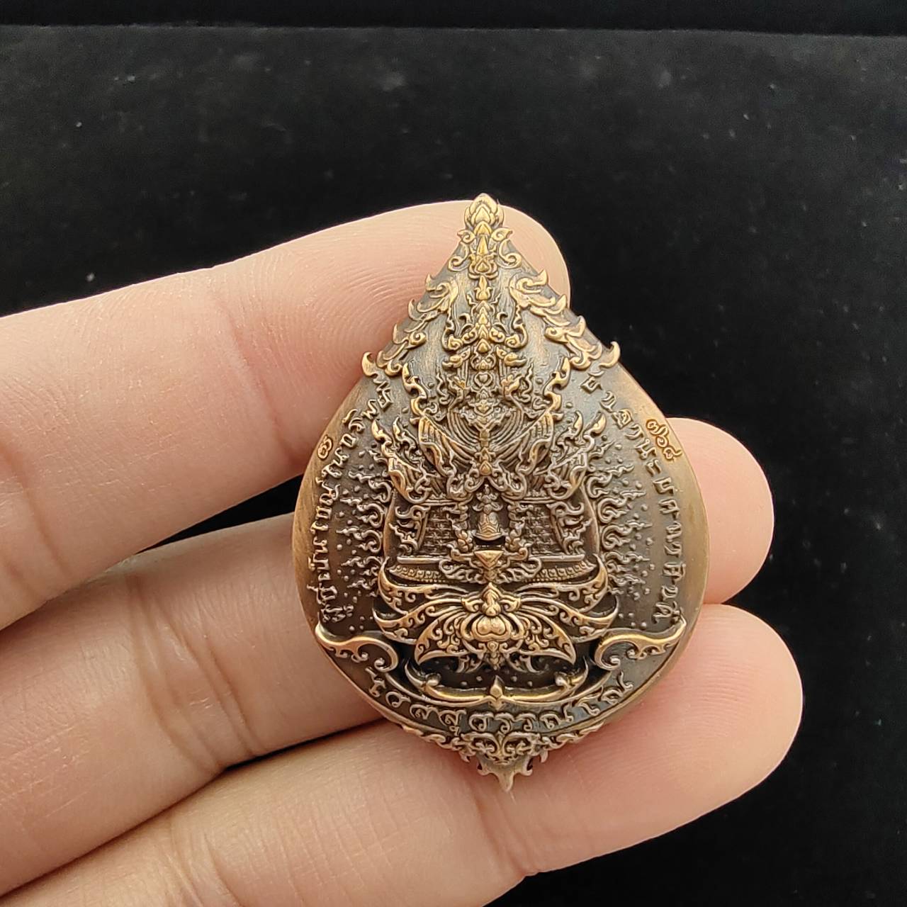 Thao Wessuwan amulet for wealth with intricate design held in hand, symbolizing prosperity and protection