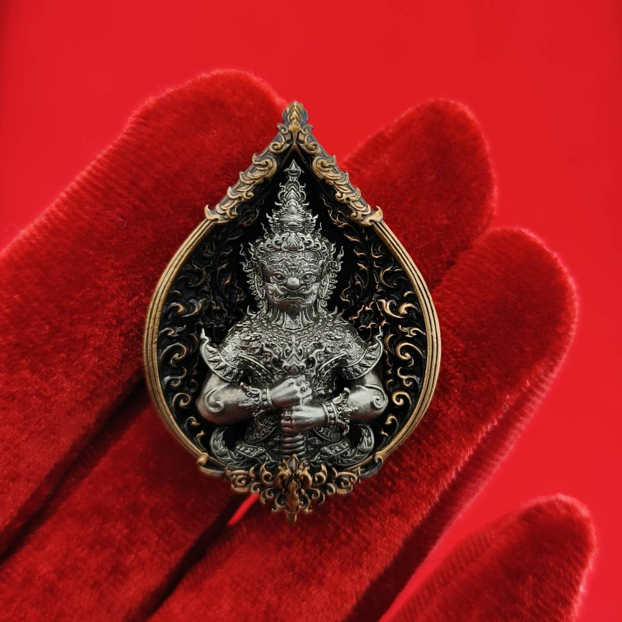 Thao Wessuwan amulet for wealth featuring intricate details and ornate design on a red background