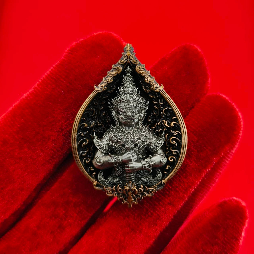 Thao Wessuwan amulet for wealth displayed on a red velvet hand, intricately designed for prosperity