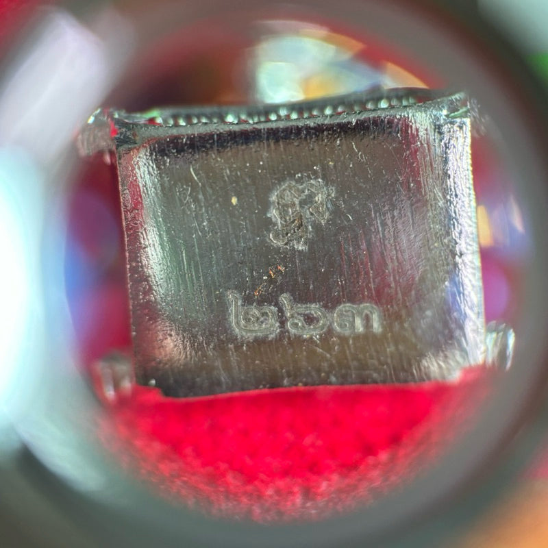 Close-up detail of Thao Wessuwan amulet Thailand showing engraved symbols on a metallic surface