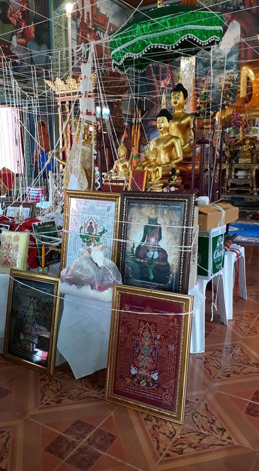 Thao Wessuwan yantra cloth displayed among ornate Buddhist decorations in a temple setting