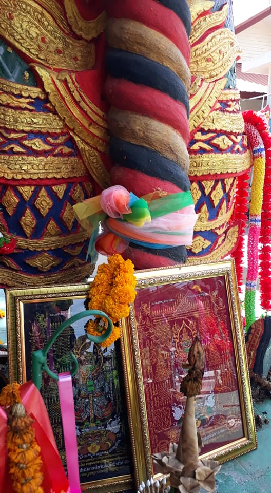 Thao Wessuwan yantra cloth displayed with religious artifacts and decorative elements in a shrine