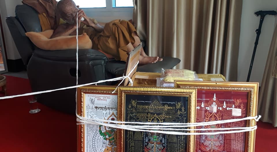 Thao Wessuwan yantra cloth showcased with monk in background, symbolizing protection and power in Thai culture