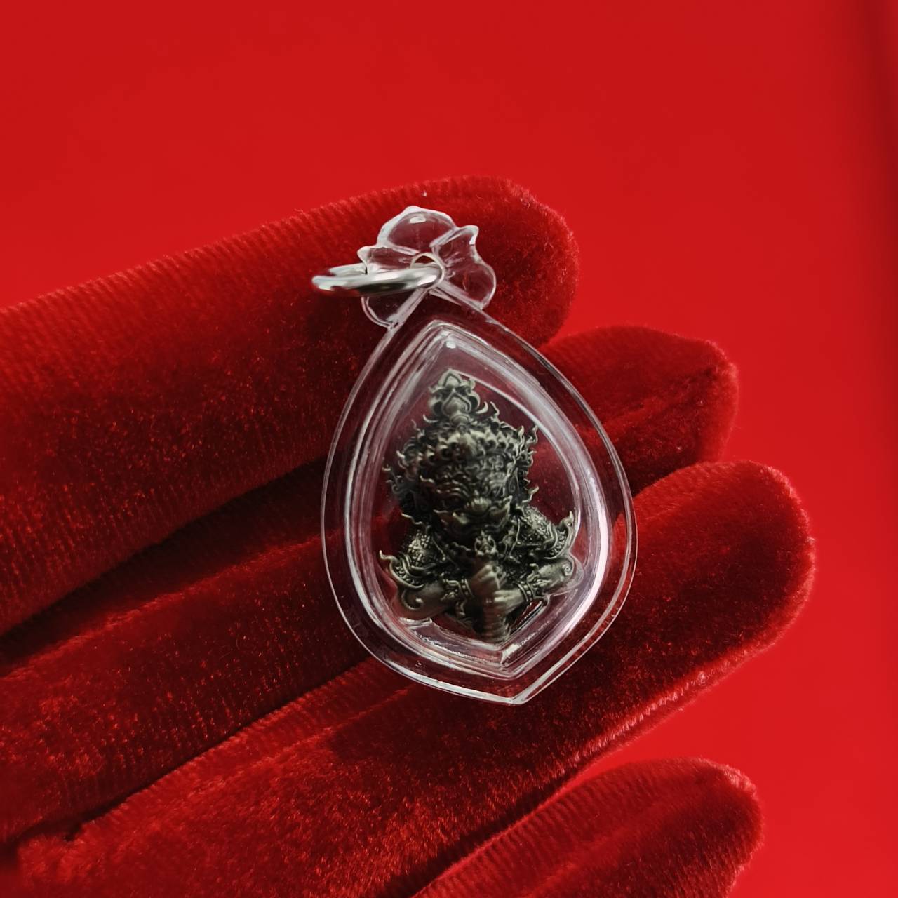 Thao Wessuwanno amulet in clear pendant holder, symbolizing protection and fortune in Thai culture