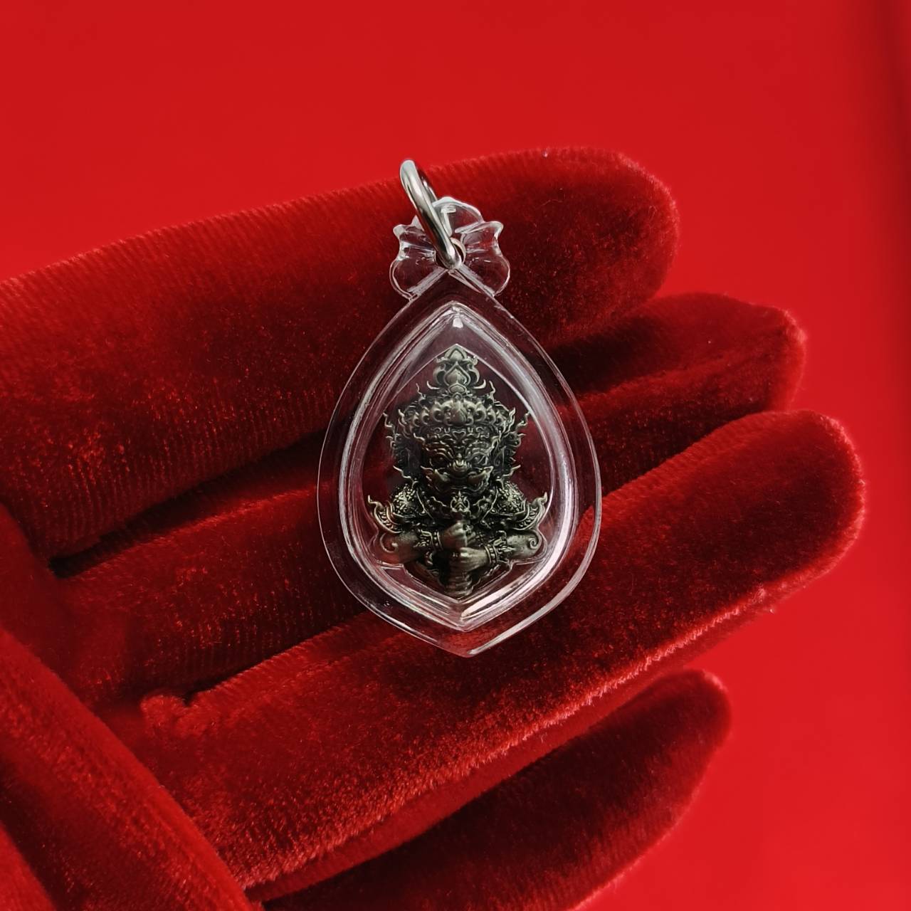 Thao Wessuwanno amulet in protective casing held in a hand, symbolizing spirituality and faith