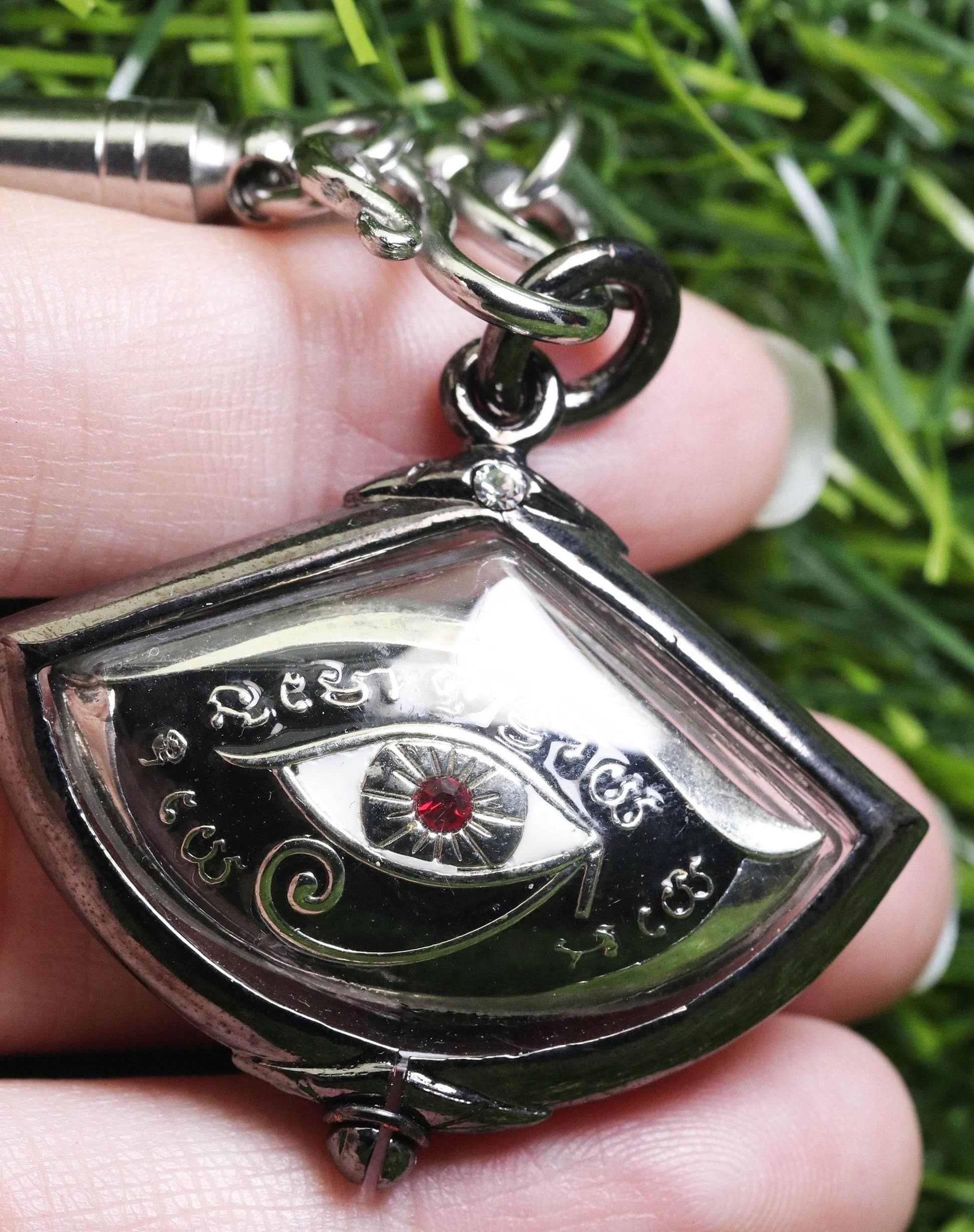 Third eye amulet for protection featuring an intricate design in silver with a red gem