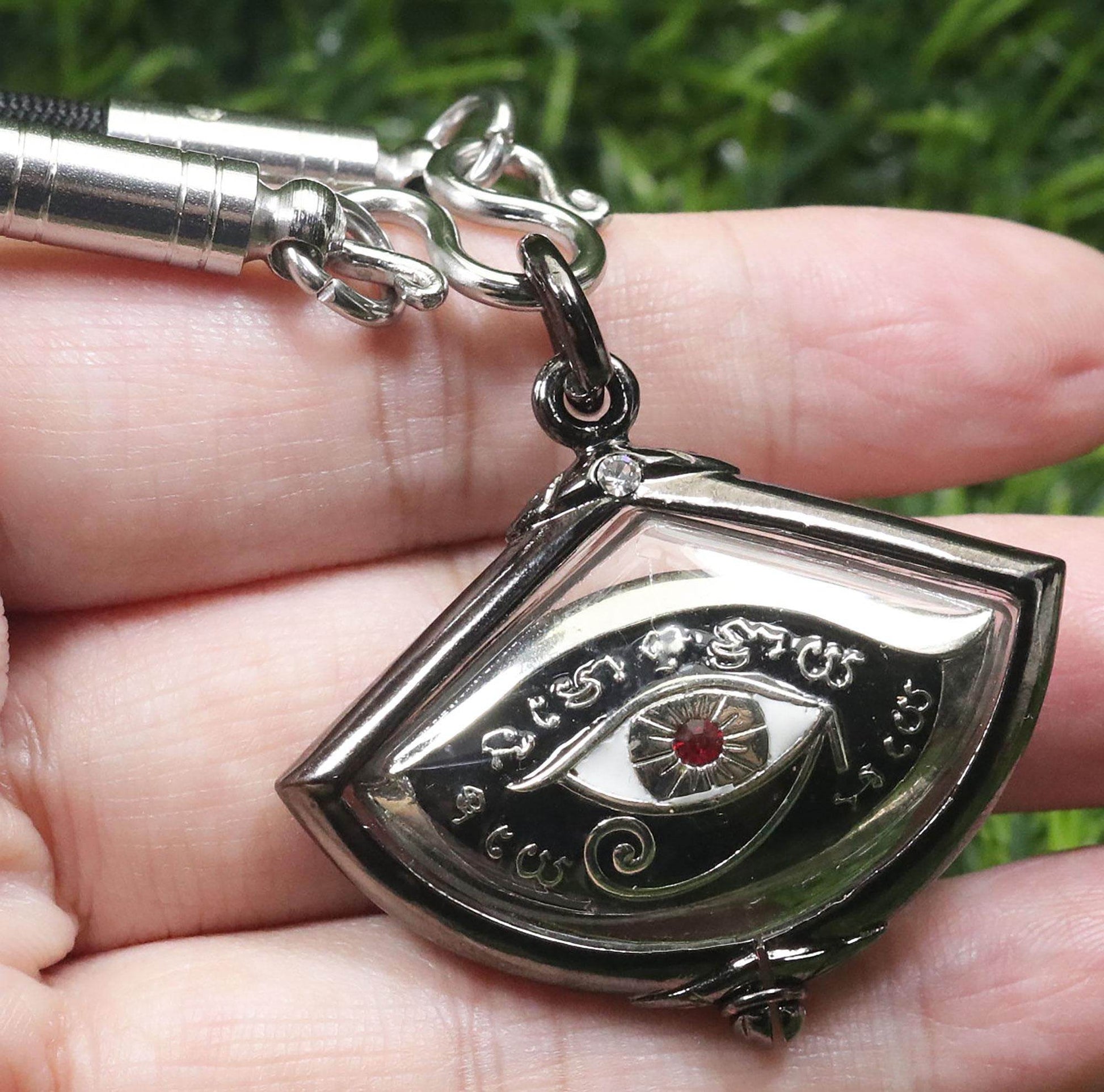 Silver third eye amulet for protection featuring intricate designs and a red gemstone