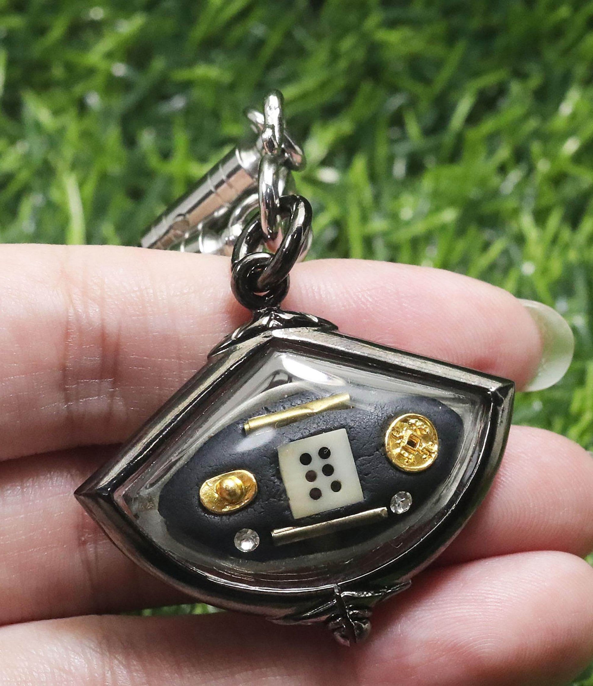 Handcrafted third eye amulet for protection featuring unique symbols and charms in a decorative case