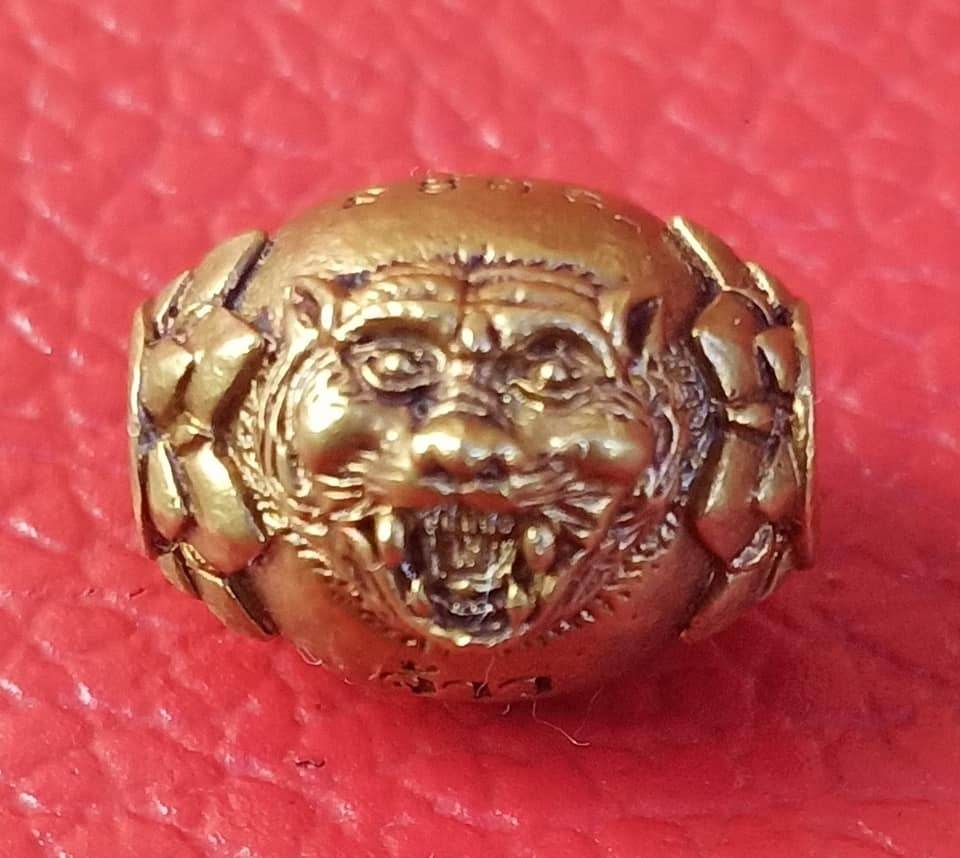 Tiger Guardian Amulet Thailand gold-tone amulet with detailed fierce tiger face on red background