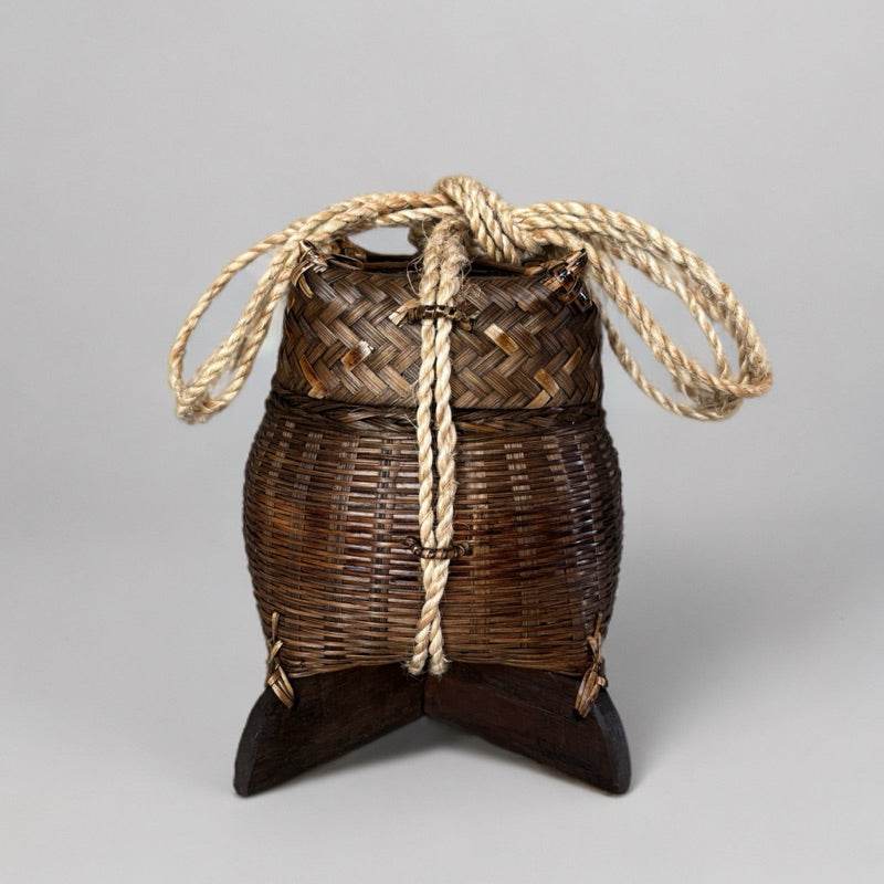 Traditional Thai storage box made from woven bamboo with rope handles and wooden base
