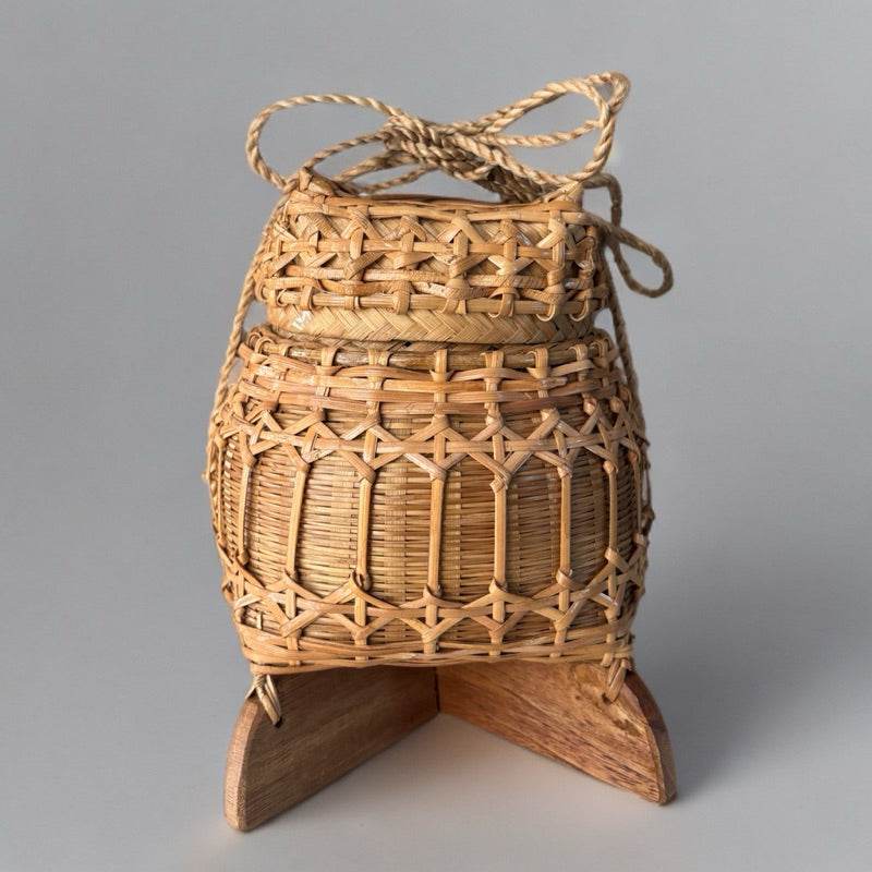 Traditional Thai storage box made of woven bamboo with wooden stand for household use