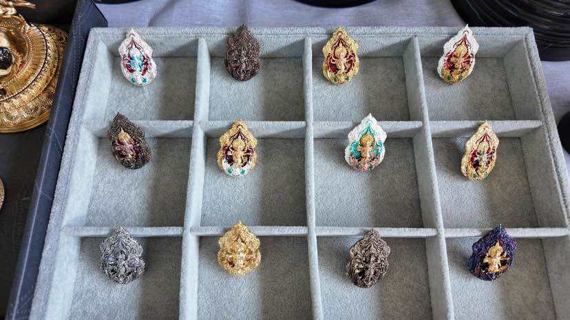 Variety of Trimurti Ganesha medallions for luck displayed in a decorative tray