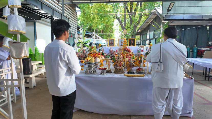 Ceremony setting with Trimurti Ganesha medallion for luck featuring floral and fruit offerings
