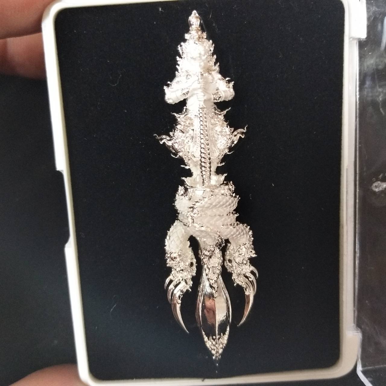 Vajra Wessuwan amulet for wealth displayed on a black background in a protective case